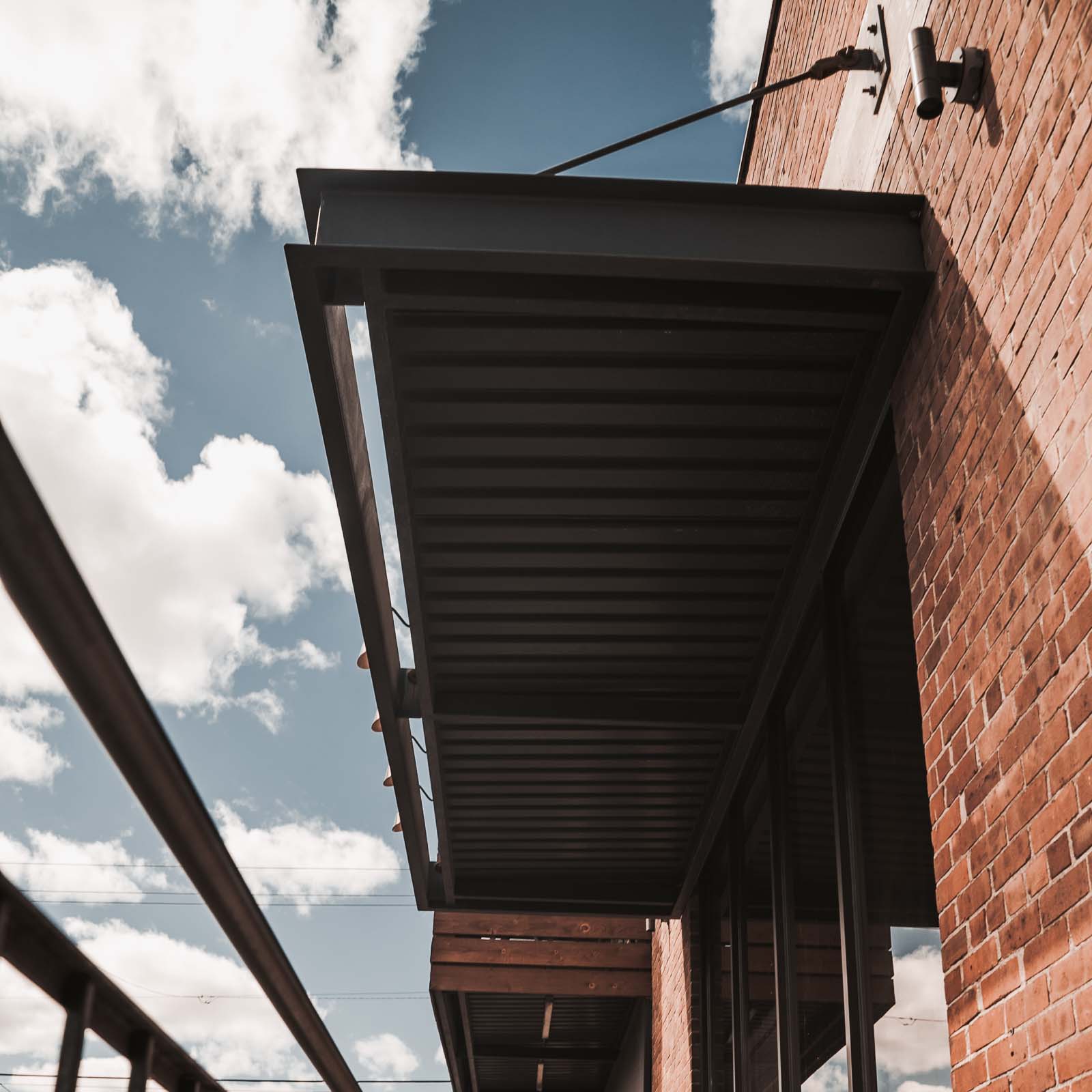 Aluminum C-Channel Canopy attached to commercial brick building