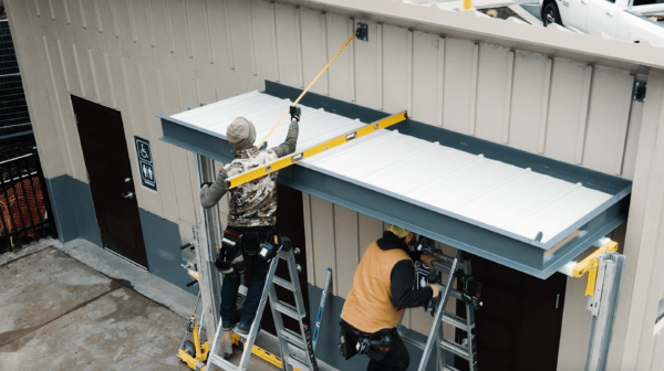 powder coated commercial canopy being installed on cement building