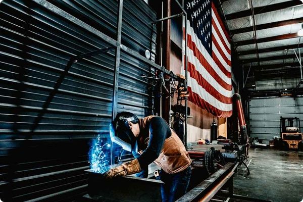 a vestis team member welding an aluminum canopy inside of a warehouse