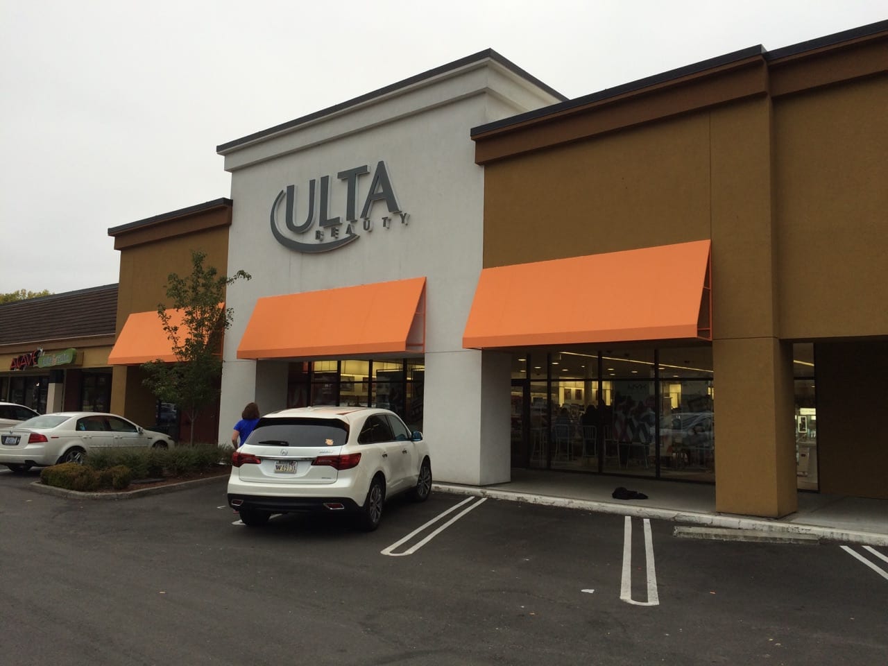 ulta retail storefront with cars parking in front and orange awnings